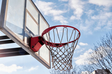 Basketball hoop and blue sky with clouds on the background