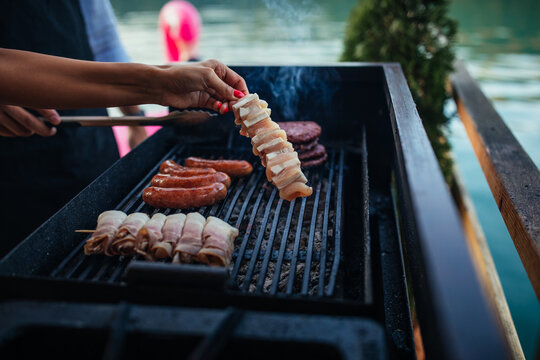 Female is grilling some delicious ingredient on barbecue outdoors