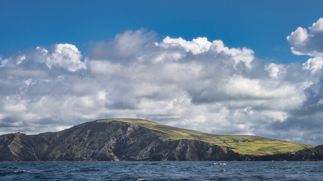 Green fields and farms in morning light on top of Kerry Cliffs seen from boat on Atlantic Ocean, Portmagee, Iveragh Peninsula, Ring of Kerry, Ireland