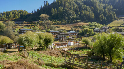 Landscape view of traditional rural mountain village with houses, chorten and prayer wall in...