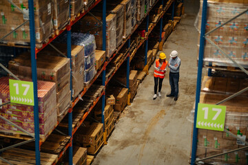 Man and woman inspecting inventory in a large distribution warehouse