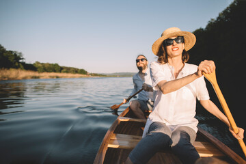 Fototapeta premium Couple enjoy summer canoe ride, copy space
