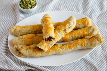 Homemade Cheesy Taco Breadsticks with Guacamole, low angle view.