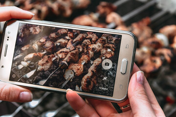 a person takes a picture of a barbecue on his phone