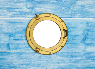 Vintage brass porthole in blue wooden wall, opening isolated with clipping path