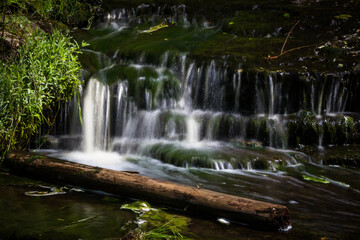 Fototapeta premium Cascading waterfall cascades in Estonia in green light at summertime