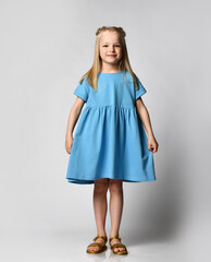 Studio portrait of a cute beautiful little girl in a blue summer dress on a white background. Kids...