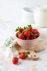 Fresh strawberries ripe delicious in colander bowl on white stone background with copy space. Selective focus.