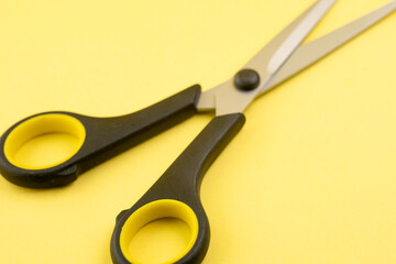 Household scissors on a yellow background