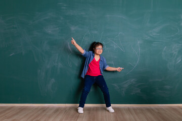 Young downs syndrome little Asian girl playing with the cheerful manner in front of green wall in...