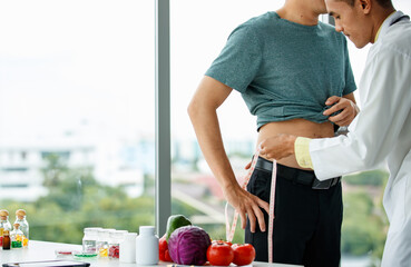 Crop nutritionist measuring waist of patient