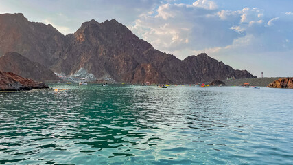 Hatta Dam Lake in mountains enclave region of Dubai, United Arab Emirates is famous tourist attraction with scenery and place to enjoy kayaking boat ride and other water adventure activities.