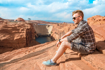 A young man admires the amazing view of Glen Canyon Dam and the Colorado River in Page, Arizona