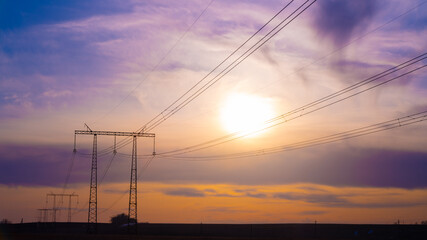 Fototapeta na wymiar Electric high voltage pole at sunset background