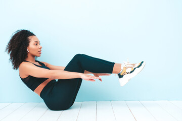 Portrait of fitness smiling black woman in sports clothing with afro curls hairstyle.She wearing...