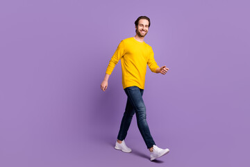 Fototapeta na wymiar Full length body size photo smiling man in casual clothes walking forward isolated pastel purple color background