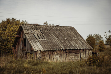 An old, abandoned log house. Deserted village in Russia. A lonely hut without people. Rotten wall...