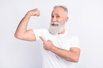 Photo of happy positive old man power show biceps point finger recommend isolated on grey color...