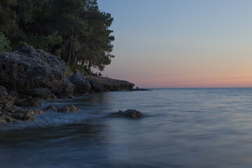 sunset on the sea near the rocky shore