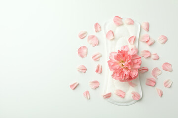 Hygiene pad with flower and petals on white background