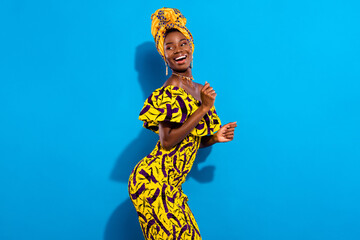 Photo of young smiling positive funky african girl dancing in yellow print dress look copyspace...