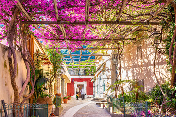 Positano, Italy. May 27th, 2020. Narrow street with a wonderful bougainvillea-covered pergola in a...