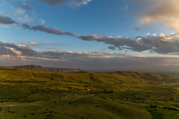 Obraz premium Beautiful summer landscape, panoramic green field and. mountains after sunset.