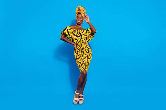 Full Size Photo Of Young Attractive Beautiful Afro Woman In Yellow Dress Traditional Turban Isolated On Blue Color Background