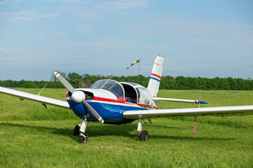 Fototapeta na wymiar Walking small propeller plane on a green field