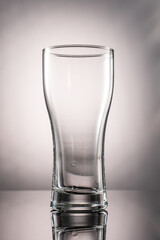 pouring beer into beer glass and foam and green transparent bottle with beer beside