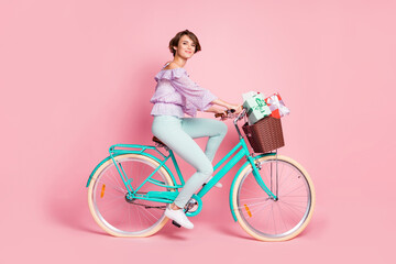 Photo of charming lady ride bicycle basket gifts wear violet blouse trousers shoes isolated pink color background