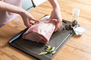 Chef cuts a meat in chopping board