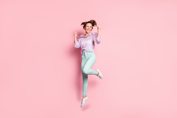 Fototapeta na wymiar Full length photo portrait of cheerful girl celebrating jumping up isolated on pastel pink colored background