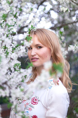 Naklejka premium woman in a long dress in a spring garden. Tender photo with white flowers