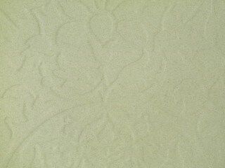 Cardboard background with an embossed floral pattern in an irregular shape. 