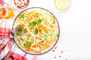 Salad coleslaw with cabbage, carrot on white kitchen table background. Top view, copy space