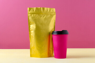 Closeup of bright and colorful packaging for coffee,tea and paper cup on the yellow surface against...