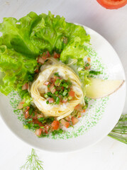 Tagliatelle nest with beshame sauce garnished with tomato, dill, lettuce in bowl on white background