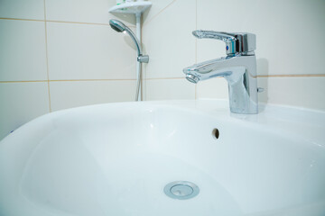 chromed metal faucet for hot and cold water  in a modern bathroom