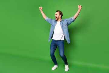 Full length body size photo of overjoyed man gesturing like winner in stylish clothes isolated bright green color background