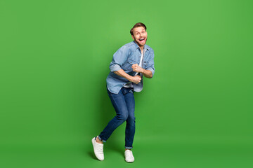 Full length body size photo of funky cool guy dancing chilling at party on weekend isolated bright green color background