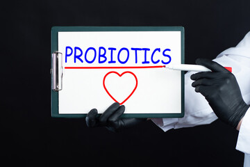 The word probiotics and heart. Useful bacteria for health. The concept of probiotics on a black...