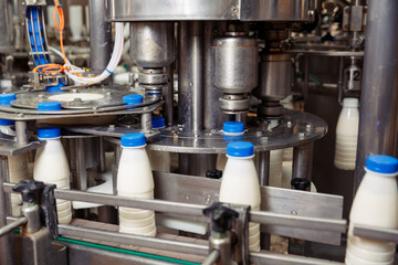 filling milk in to plastic bottles at the factory. equipment at the dairy plant