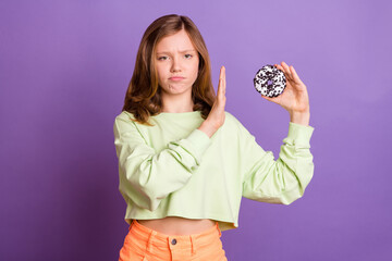 Photo of young girl show no stop refuse deny sweet donut diet calories isolated over purple color...