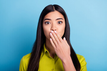 Photo of young woman cover hand mouth oops fail mistake tell secret isolated over blue color...