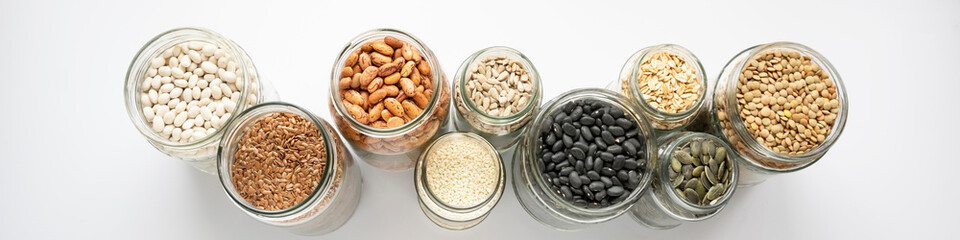 Variety of legumes and seeds in glass jars. Zero waste storage, no plastic, healthy food concept