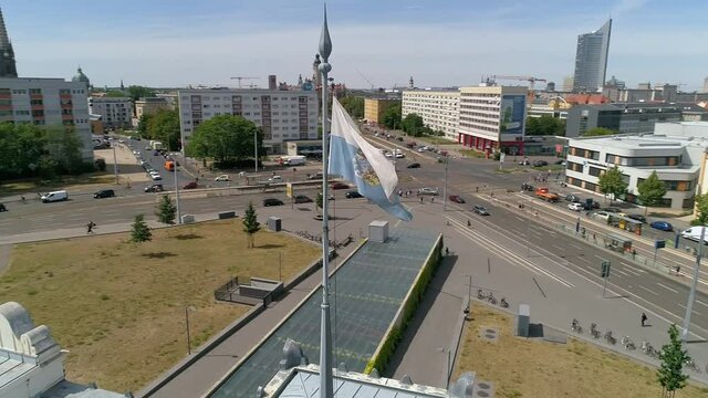 Pan across the square in front of the former train station. Bavarian train station in Leipzig. Flage blows in the wind.