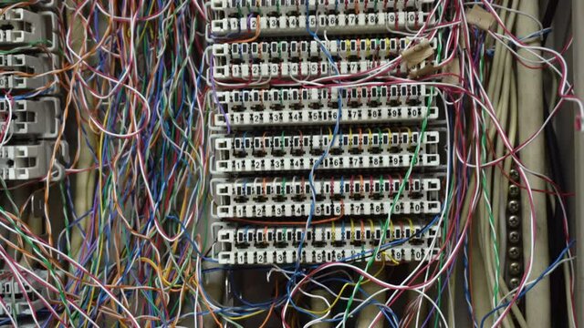 Inside a PBX telephone booth that has a number of connecting cables in many colors in the analog system.