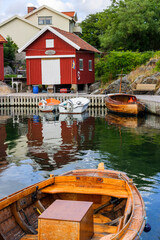 Obraz premium Idyllic view with a red boathouse and boats at the jetty