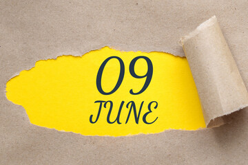 june 09. 09th day of the month, calendar date.Hole in paper with edges torn off. Yellow background...